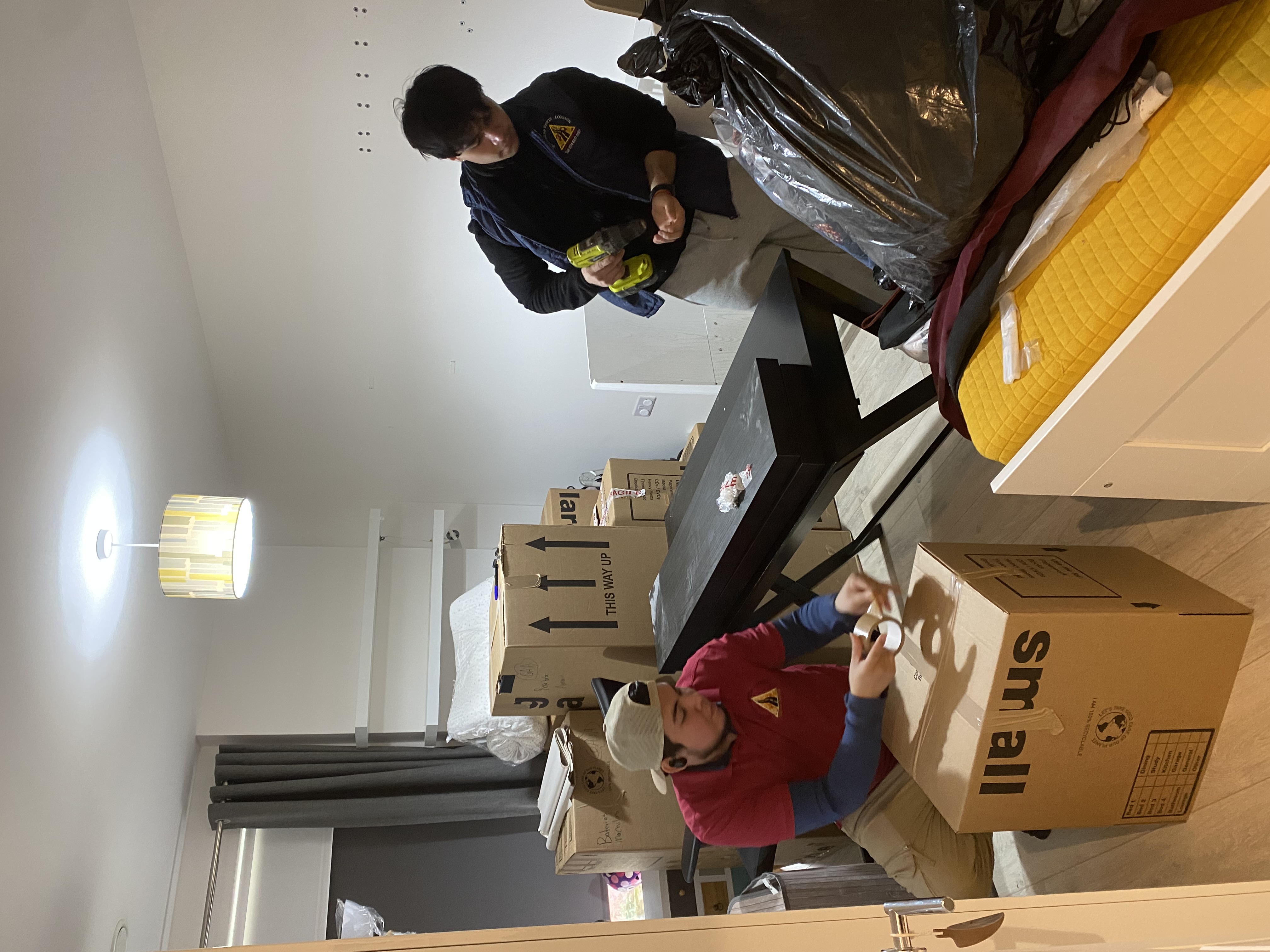2 workers packing a room to secure for transport in Colliers Wood